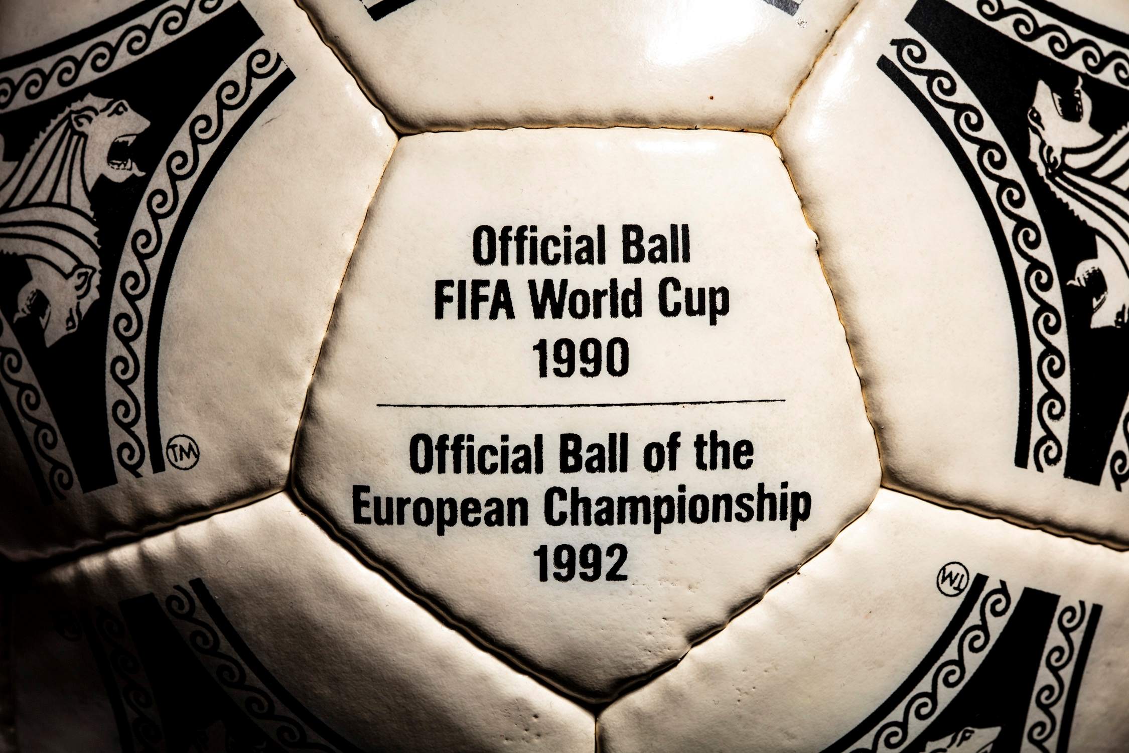 Plano en zoom del panel con inscripción Official Ball FIFA World Cup 1990 y European Championship 1992