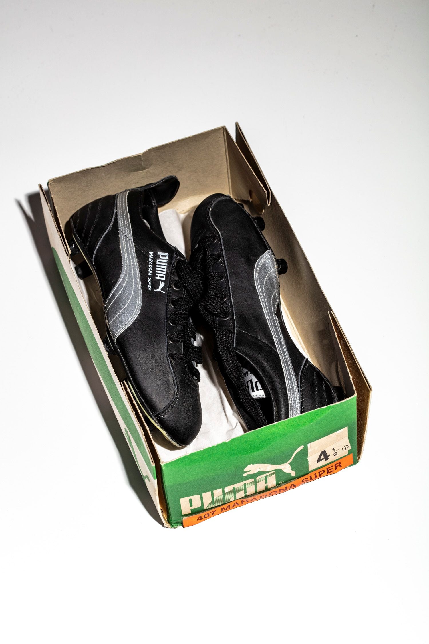 Vista del par de botas Maradona Super dentro de su caja original. Llave de ajuste de tacos incluida.