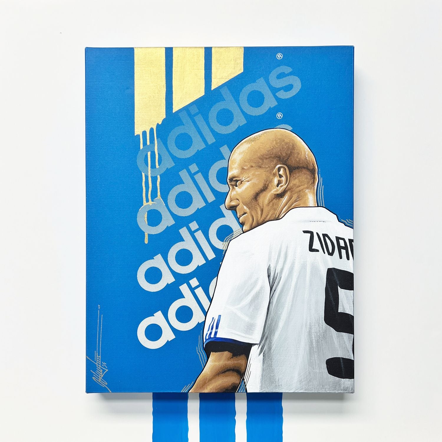 Retrato de Zinedine Zidane pintado a mano con acrílico sobre la tapa original de una caja de zapatillas Adidas de edición retro, enmarcado en caja flotante blanca de 50 × 50 cm.
