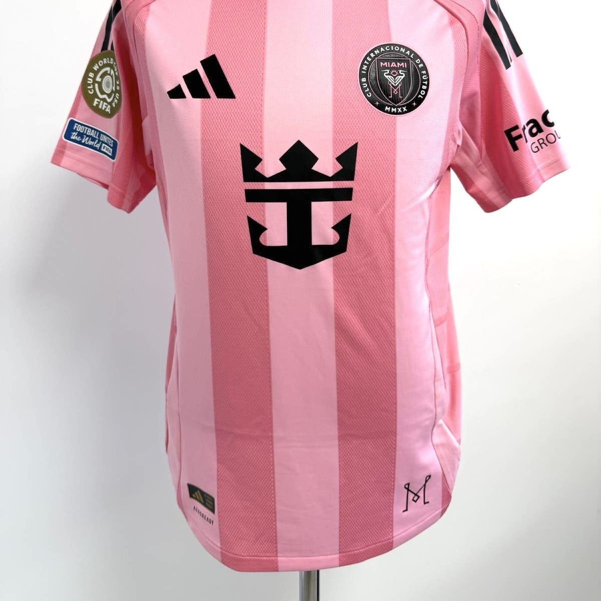 Vista frontal de la camiseta matchworn de Leo Messi, se observa el escudo del club, logo adidas y patrocinador principal, con los parches oficiales del torneo en brazo derecho.