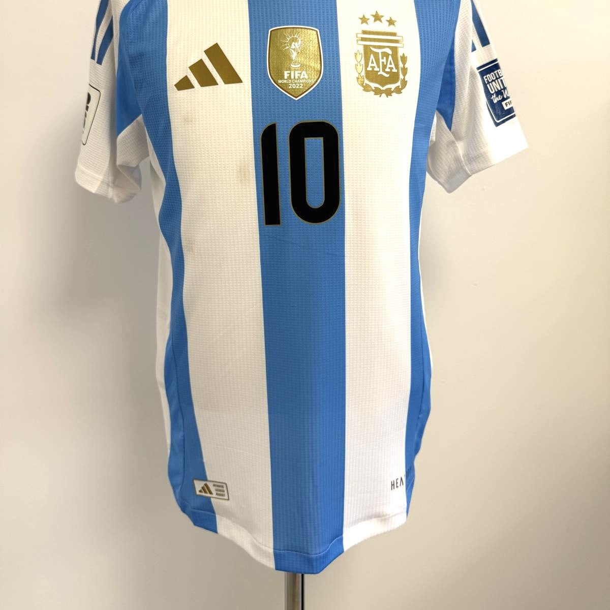 Vista general en plano anterior de la camiseta. Detalle del Logo de la marca, escudo FIFA y AFA con dorsal 10 en posición central