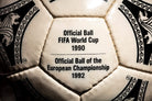 Plano en zoom del panel con inscripción Official Ball FIFA World Cup 1990 y European Championship 1992