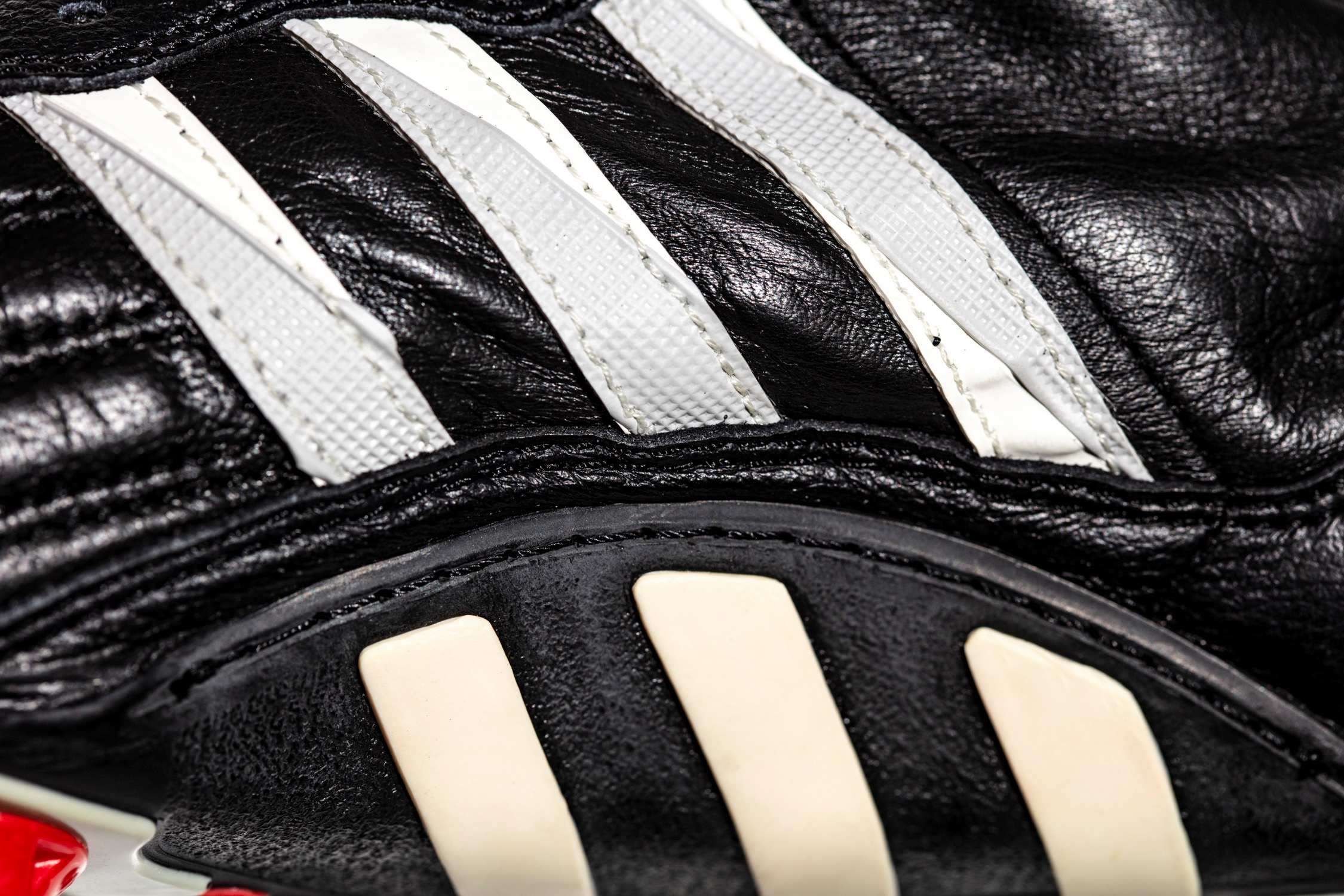 Plano detalle de las tres ranjas adidas con continuación a la suela. 