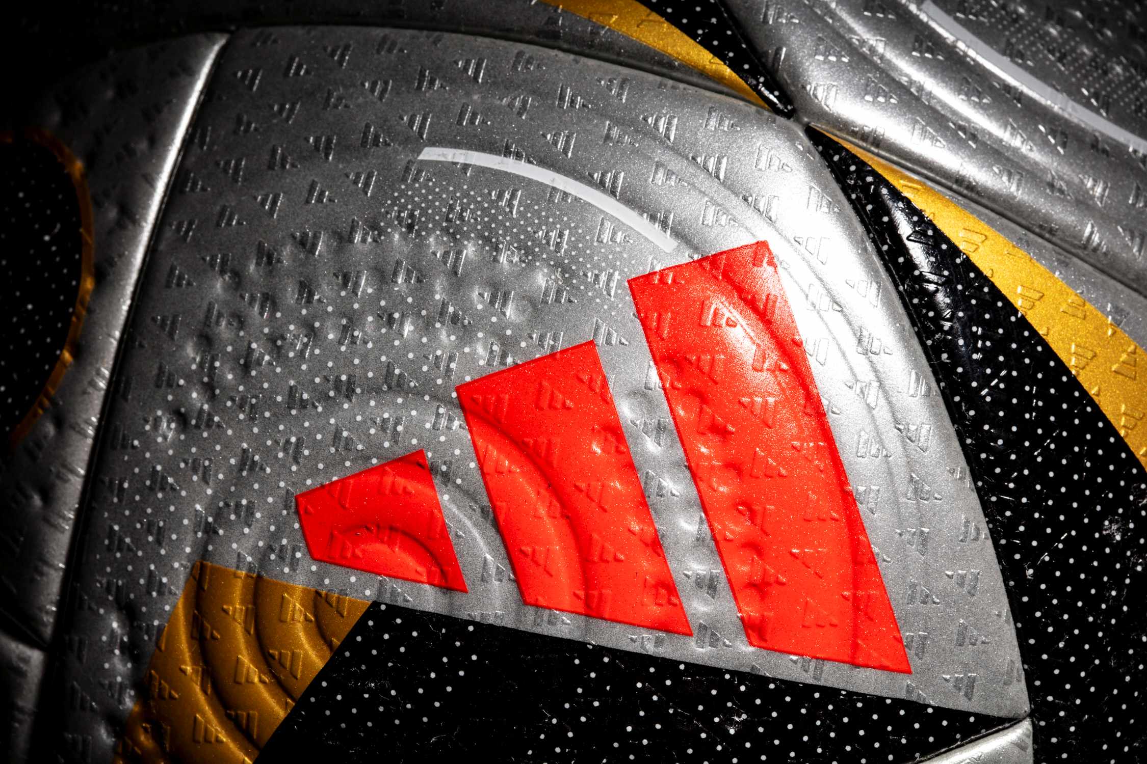 Detalle ampliado del logo adidas en color rojo.