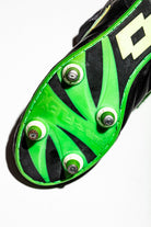 Detalle de la suela Punto Flex de Lotto, combinando el color verde y negro. Vista de tacos enroscados de aluminio
