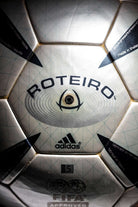 Vista principal de la inscripción Roteiro con vávula de goma negra vista.Se aprecia el logo FIFA APPROVED.