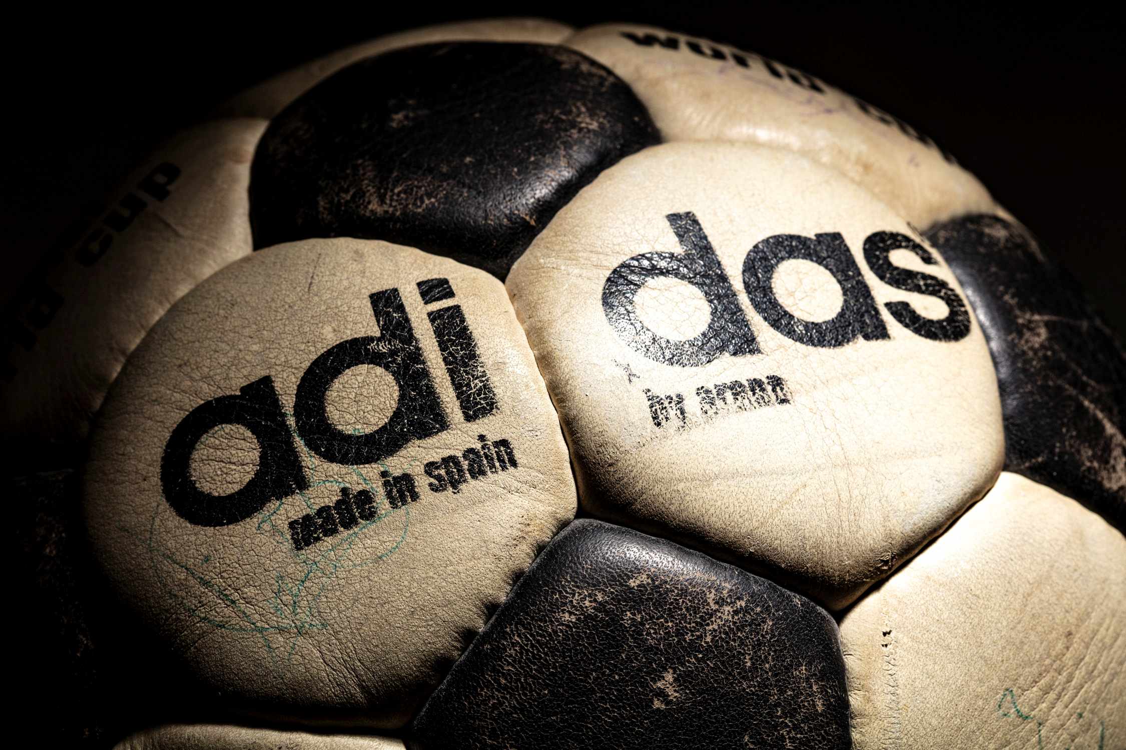Detalle de la inscripción adidas con la separación propia de los balones anteriores a 1975. Se observa el cuero natural con desgaste.