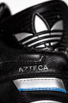 Detalle de la serigrafia del modelo Azteca y de la flor de adidas de la lengüeta de goma