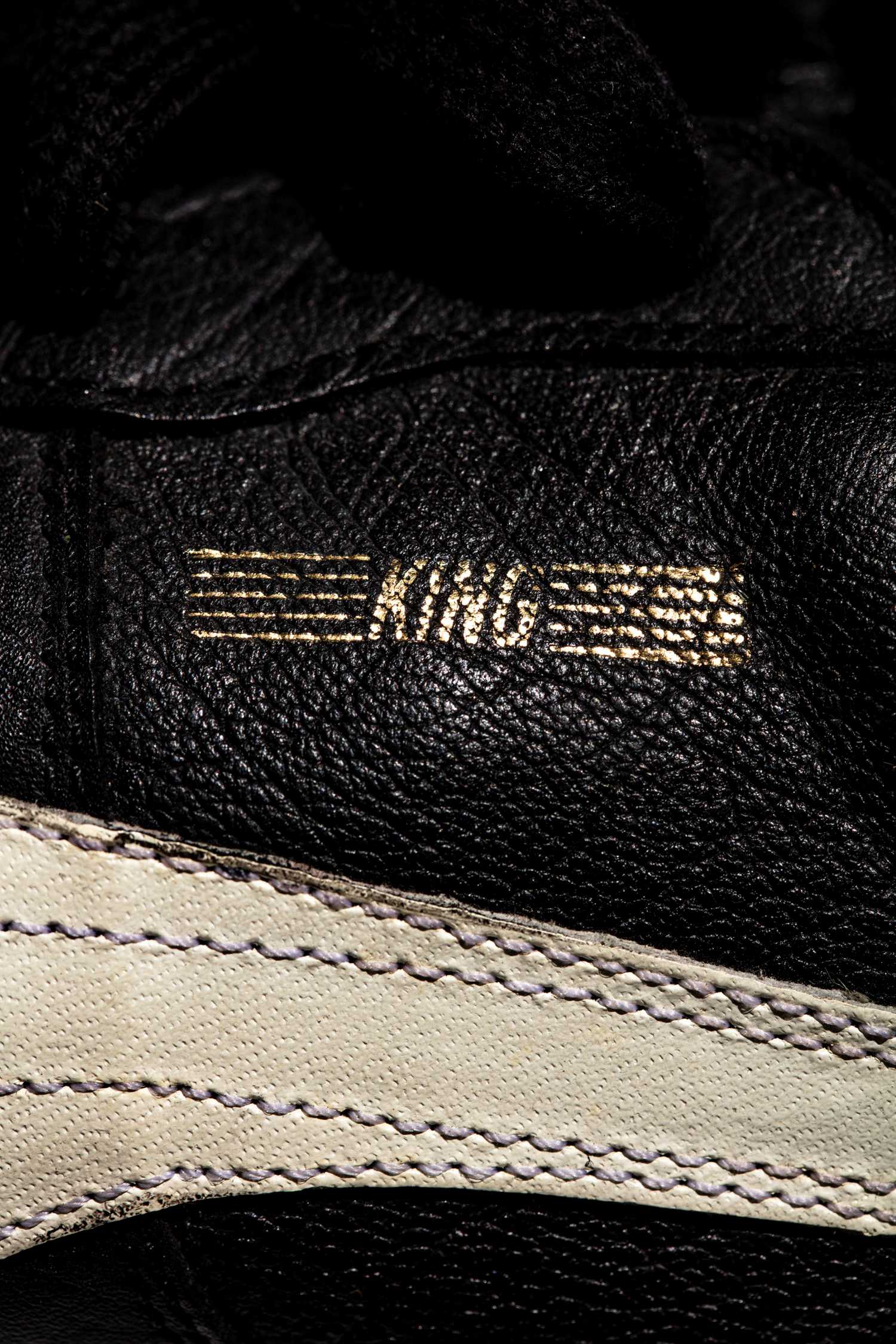 Vista del logo KING en color dorado y detalles de las costuras del logo PUMA.