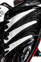 Plano detalle de las tres franjas adidas en color blanco y textura granulada.