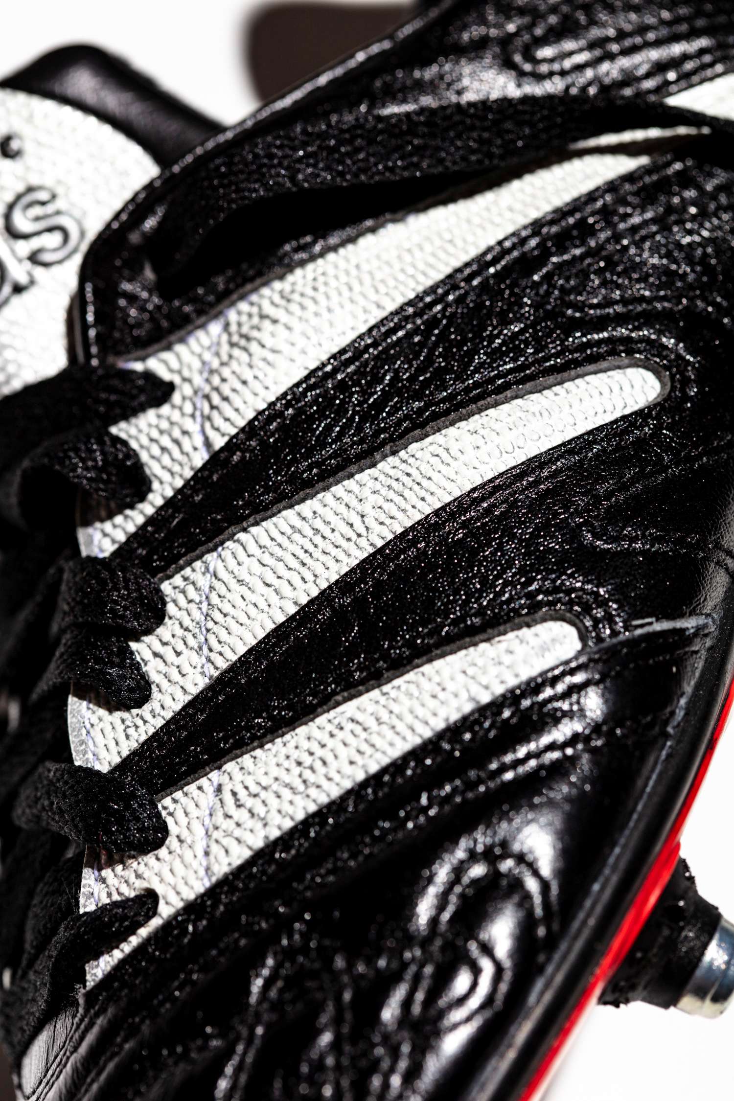 Plano detalle de las tres franjas adidas en color blanco y textura granulada.