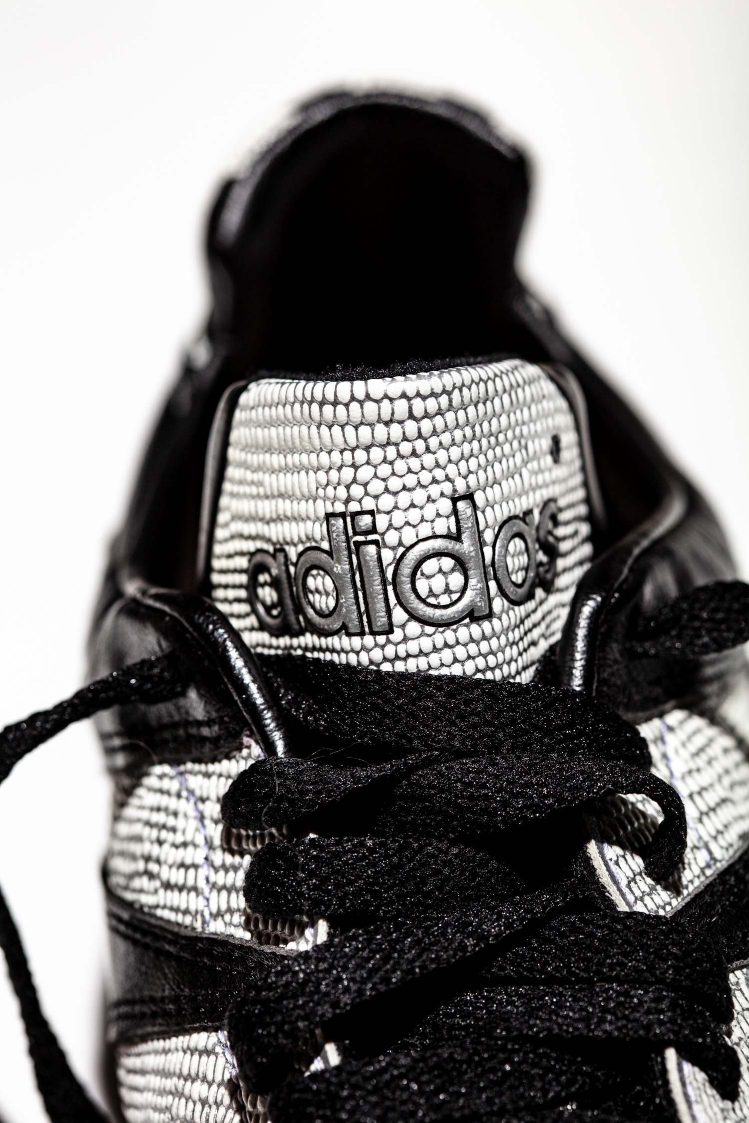 Lengüeta adidas de pequeño tamaño, no flexible y granulado a juego con la franjas adidas.