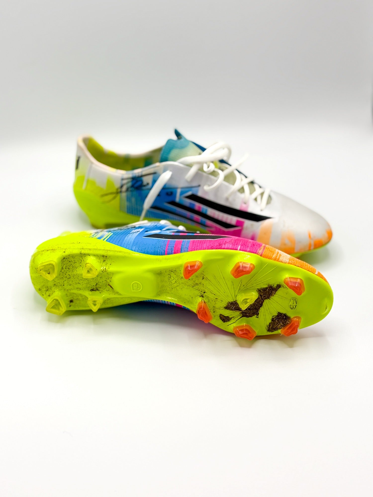 vista del par de botas pero se observa restos de tierra y césped en la bota derecha