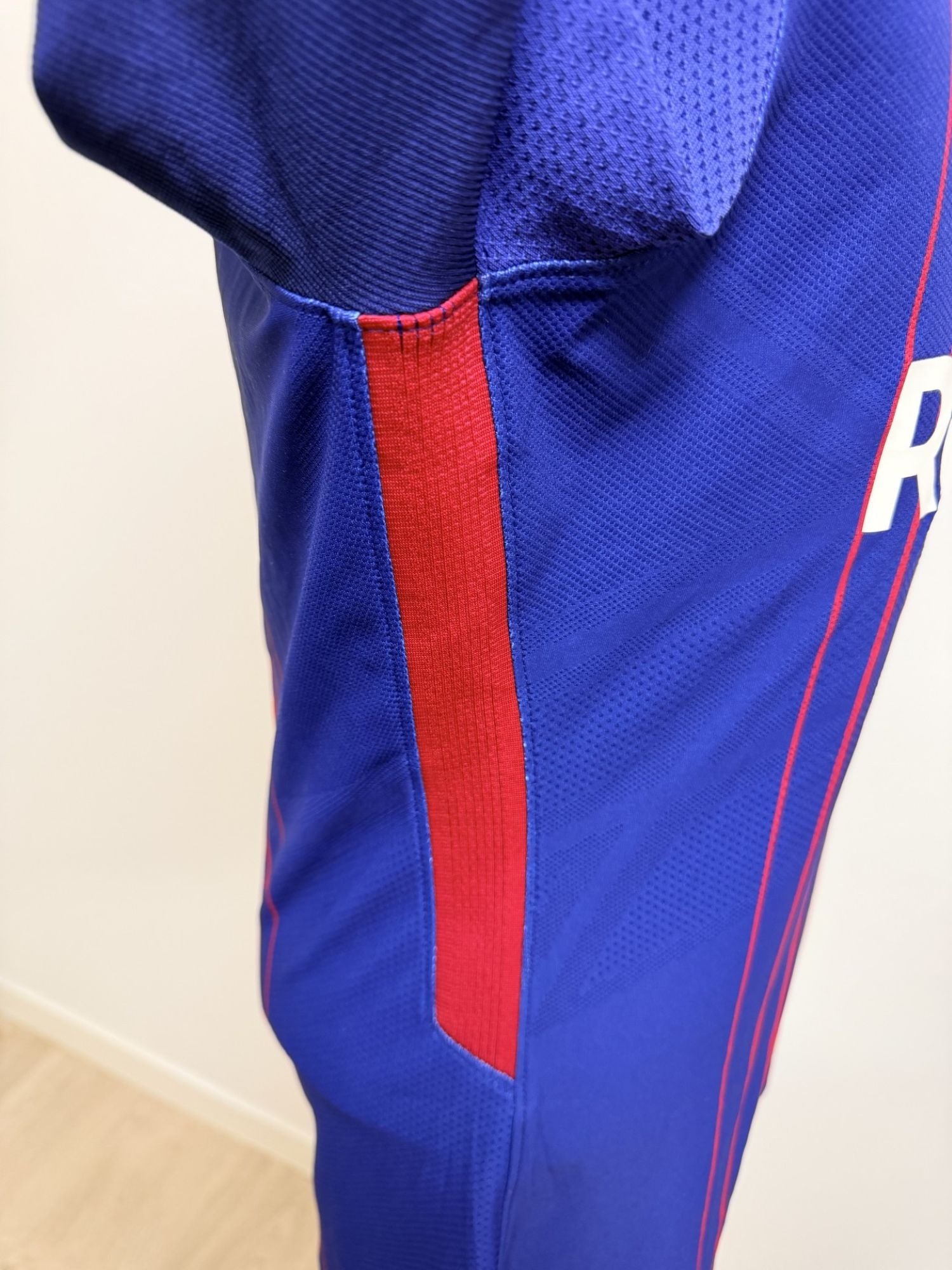 Vista lateral de la camiseta dónde se observa el tejido y la tira elástica del modelo.