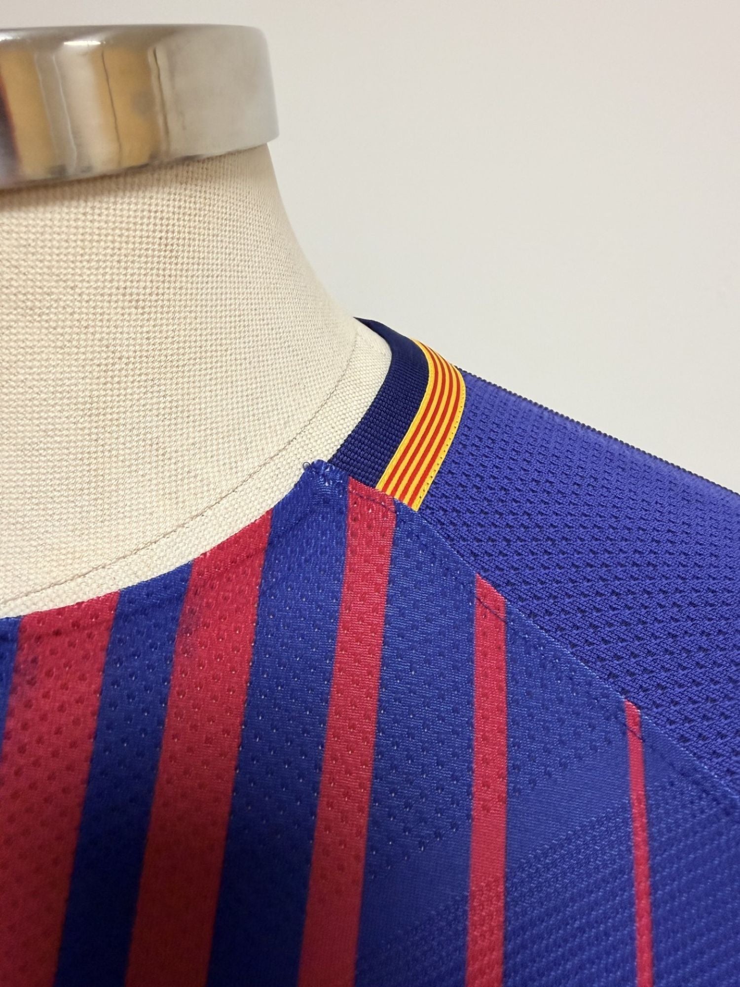 Plano detalle de las costuras del cuello y de la tira con la bandera catalana (vista lateral izquierda)
