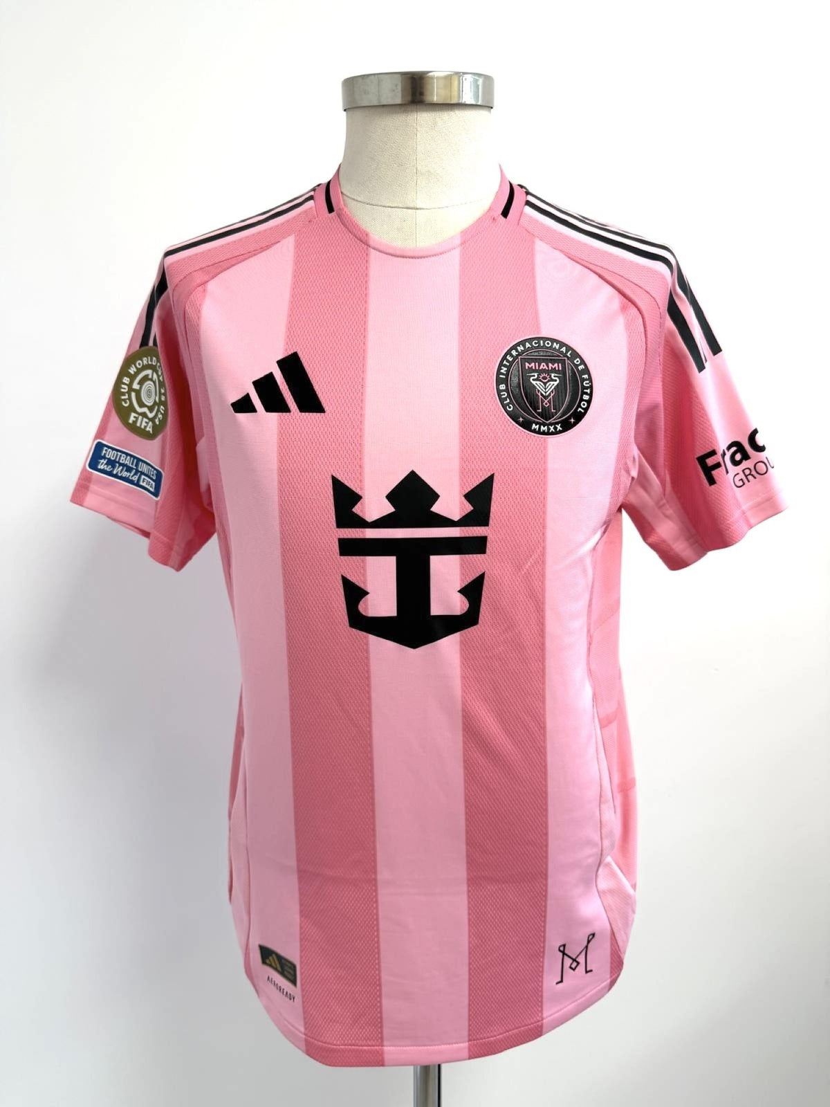 Vista frontal de la camiseta matchworn de Leo Messi, se observa el escudo del club, logo adidas y patrocinador principal, con los parches oficiales del torneo en brazo derecho.